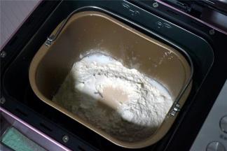 将黄油除外的食材按照先液体后固体的顺序放入面包机桶里，启动揉面程序揉面20分钟。