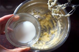 黄油软化后加入糖粉，搅打至蓬松状态后，分次加入牛奶，搅打至完全融合。