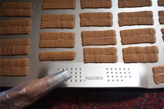 在无边烤盘上，挤出约6cm长的条状，在旁边紧挨着挤上另外一条。