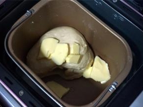 程序结束后，加入黄油，再次启动揉面程序，时间15分钟。两个程序结束后，面团可以拉出粗燥的手套膜，足矣。