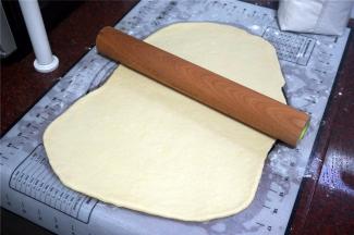 将发酵完毕的面团擀开排气。