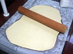 将发酵完毕的面团擀开排气。