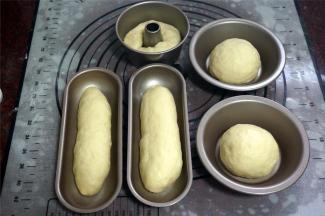 取两份分别揉圆，放入汉堡包坯模具中，然后取两份揉成长条状，放入热狗模具中，剩下一份揉成长条，放入4寸的不粘中空模具中。