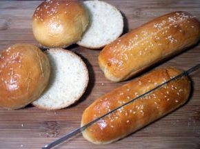 开始制作汉堡包和热狗。先用等分器从汉堡包坯底部切开，高度约1~1.5厘米处。热狗坯从中间切开，但是不要切断。