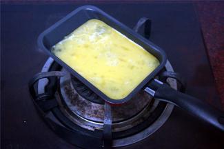 用煎蛋锅煎两个鸡蛋备用（鸡蛋打散后拌均匀，放入少许食盐调味）。
