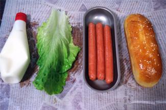 火腿肠用热油炸一会，捞起，准备生菜叶，色拉酱，开始组装热狗。