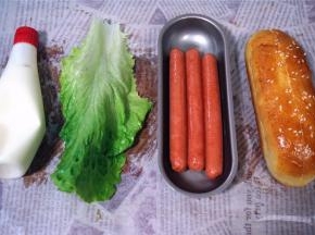 火腿肠用热油炸一会，捞起，准备生菜叶，色拉酱，开始组装热狗。