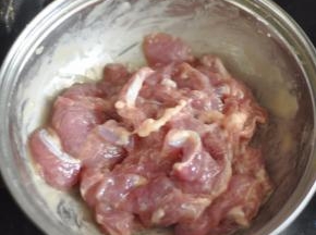 猪肉切片，加入蛋液、淀粉、鸡粉腌制片刻。