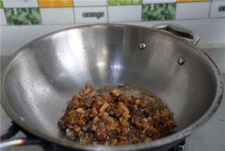 锅里将菜脯肉丁下锅煸炒出味。