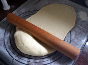 倒入面团，用擀面杖擀开排气，然后分成6等份，静置松弛10分钟。