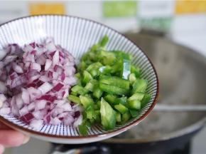 再将洋葱及菜椒下锅同炒至出味。