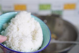 将冷饭下锅，炒至饭粒松散。