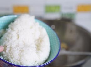 将冷饭下锅，炒至饭粒松散。