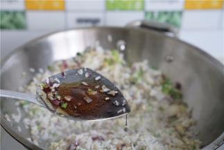 加入少许的酱油及细盐，炒至饭粒挂味。