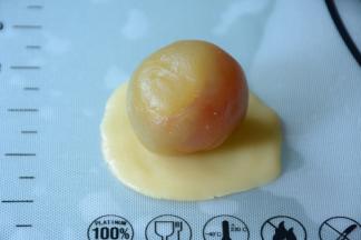 取一饼皮揉圆压成大小合适的圆形，取一份馅儿包入。