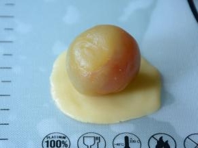 取一饼皮揉圆压成大小合适的圆形，取一份馅儿包入。