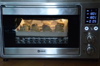 烤箱预热180度，现将月饼烘烤5分钟。然后取出，蛋黄加入少量清水，混合均匀。用刷子蘸上少量蛋液在月饼上刷上一层继续180度烘烤10—12分钟就可以了。