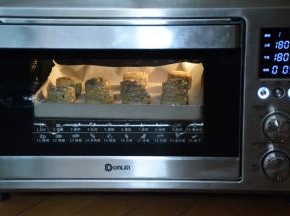烤箱预热180度，现将月饼烘烤5分钟。然后取出，蛋黄加入少量清水，混合均匀。用刷子蘸上少量蛋液在月饼上刷上一层继续180度烘烤10—12分钟就可以了。