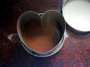 将拌好的黑巧克力慕斯液倒入到模具中，盖上顶盖，放入冰箱冷藏1个小时以上让其凝固，然后再继续做第二层的慕斯。