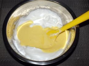 然后将混合物倒入剩余的蛋白中，切拌均匀。