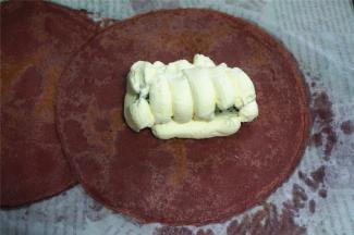 班戟皮冷却后，在贴着锅的那面包馅，挤上淡奶油，放入火龙果肉，先左右包，再前后包。