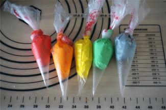 剩余的淡奶油分成6份，其中白色的一份要多留点，其余5份分别添加色素调色，并装入裱花袋。