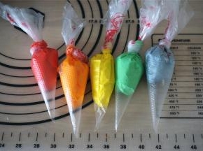 剩余的淡奶油分成6份，其中白色的一份要多留点，其余5份分别添加色素调色，并装入裱花袋。