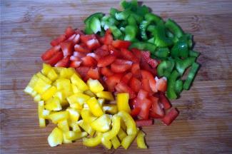 在面团发酵的过程，准备披萨馅料。首先将彩椒切成小段，备用。