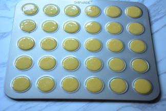 将混合好的面糊装入裱花袋，挤入模具中。