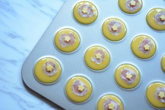 在芝士片上压出花朵，放在香肠薄片上。