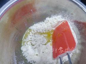 碗里打入鸡蛋，并倒入细砂糖和柠檬皮屑混合物，用手动打蛋器或刮刀拌匀，不用将鸡蛋打发，再倒入过筛后的低筋面粉。