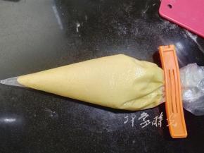 搅拌到混合物成光滑的泥状后，放入冰箱冷藏一小时后取出。这时候面糊已经凝固。在室温下放置片刻，待面糊重新恢复到可流动的状态时，把面糊装入裱花袋，挤入玛德琳模具，大约9成满。