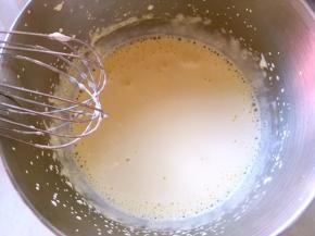 将煮开的牛奶一点点加入到蛋黄中，边加热边搅拌，先加入三分之一