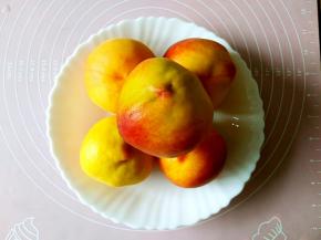 z黄桃放在清水中，用软毛刷子刷干净，再过一遍清水。