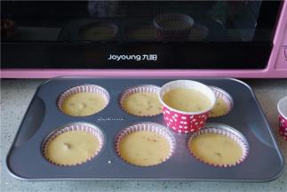 将冷藏好的蛋糕糊挤在纸托里。