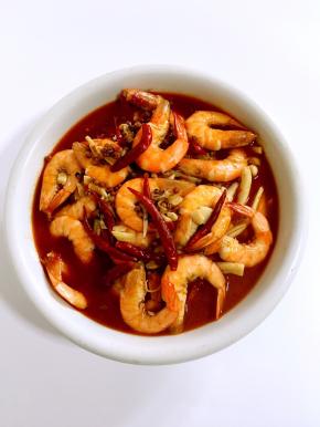 煮好的虾连汤汁一起倒进盛配菜的碗里。
