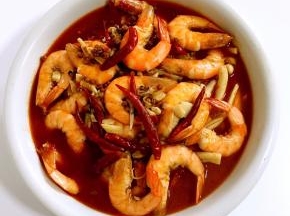 煮好的虾连汤汁一起倒进盛配菜的碗里。
