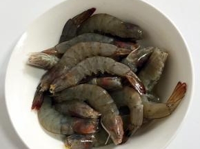 将虾放入碗中，加入1勺料酒去腥，再放1小勺盐增加底味。抓均匀后腌制15分钟。不用剥虾壳，这样更能锁住虾本身的鲜味。