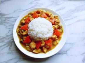 取一块大一点的盘子，将米饭放在中间，用勺子把咖喱鸡盛入一圈，如图。