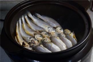 再加入少许玉米油加热，再将洗净控水的小黄鱼摆放在锅里。