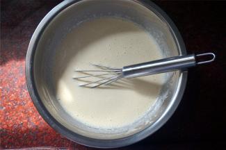 将烧开的牛奶分次倒入到蛋糕糊中，边倒入边搅拌，然后放置一旁冷却。