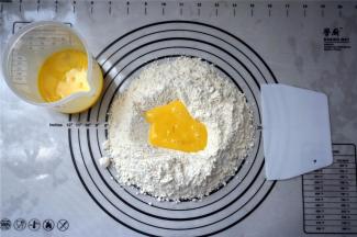 富强粉，泡打粉混合过筛到揉面垫上，然后中间挖空，倒入全蛋液。揉成湿润的面团，非常粘软的状态，据说这样做出来的沙琪玛才松软。
