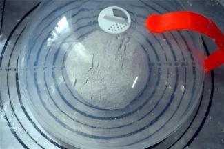 在面团表面撒上少许玉米淀粉，揉圆，盖上盖子，静置松弛15分钟。