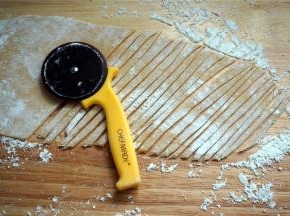 在面团上撒上玉米淀粉防粘，然后擀成0.2厘米厚的薄片。用披萨轮刀切成细坯条，在皮条上撒上玉米淀粉防粘。