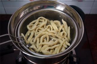 将一条坯条放入油锅试油温，若坯条迅速浮起涨大表示油温可以，开始放入坯条，炸坯条。