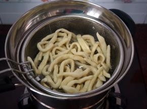 将一条坯条放入油锅试油温，若坯条迅速浮起涨大表示油温可以，开始放入坯条，炸坯条。