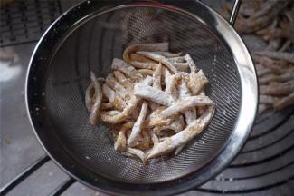 起油锅，同时将细坯条过筛，筛掉多余的淀粉。