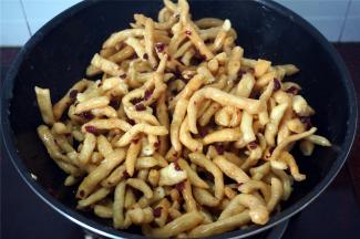 熄火，倒入炸好的坯条和蔓越莓干，趁热快速翻拌，让每一根坯条都能沾到糖浆。