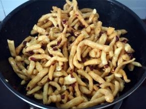 熄火，倒入炸好的坯条和蔓越莓干，趁热快速翻拌，让每一根坯条都能沾到糖浆。