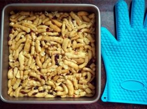 将拌好的坯条倒入方形不粘活底模具内，带上隔热硅胶手套，趁热压紧。